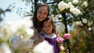 A lady and her granddaughter together in a rose garden