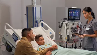 Healthcare professional with patient and family at hospital bedside