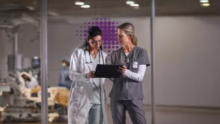 Nurses looking at screen with purple dots in background 