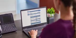 Woman on laptop viewing Sharesource remote patient management