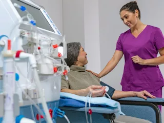 A healthcare professional is talking to her patient, who is receiving HD therapy