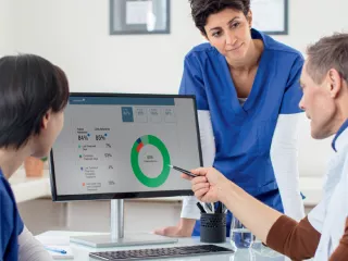 Professionals reviewing Sharesource Analytics data on a monitor